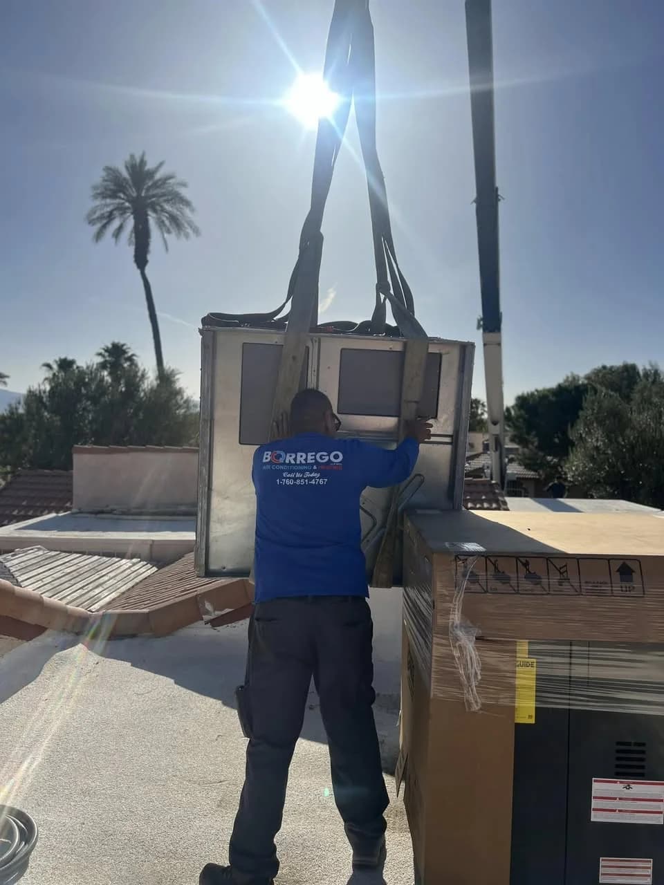 Borrego technician guiding rooftop unit into place