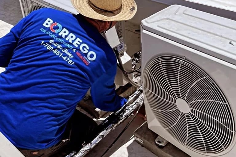 Technician installing mini-split outdoor unit